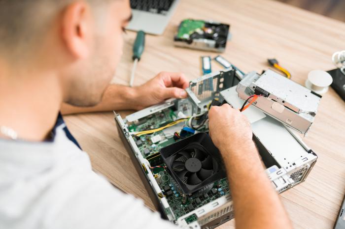 e022254759_vista-superior-de-um-tecnico-hispanico-consertando-o-ventilador-do-computador-jovem-conectando-uma-nova-peca-componente-em-uma-cpu_700