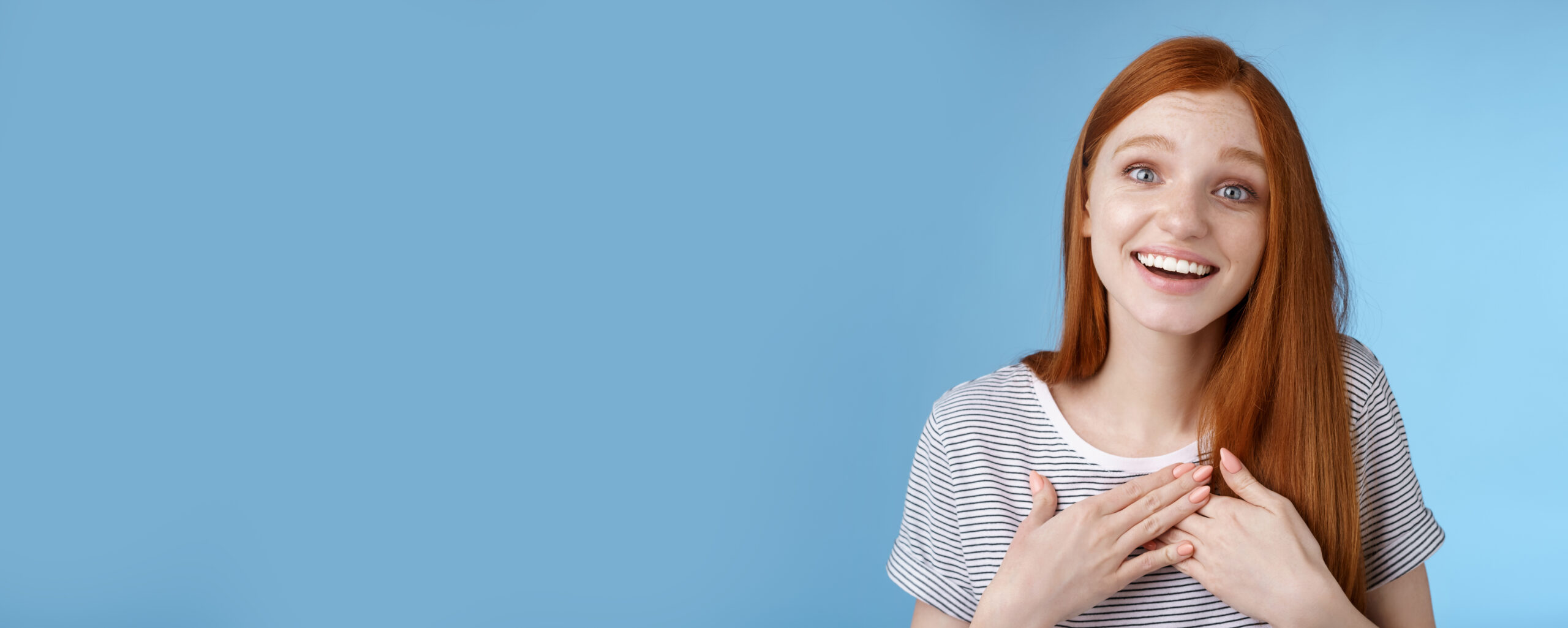 Kind fascinated touched romantic passionate redhead girl blue eyes sighing admiration delight touch heart palms smiling happily grinning grateful thanking friend express gratitude, studio background