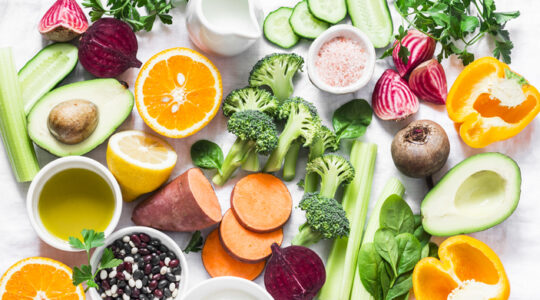 Five best vitamins for beautiful skin. Products with vitamins A, B, C, E, K – broccoli, sweet potatoes, orange, avocado, spinach, peppers, olive oil, dairy, beets, cucumber, beens. Flat lay, top view