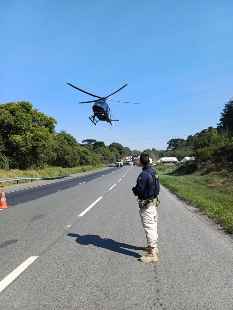 Policial aguarda pouso de helicóptero para resgate de vítima de acidente na BR-277. (Divulgação)