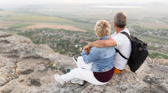 full-shot-senior-couple-sitting-cliff_23-2148656253