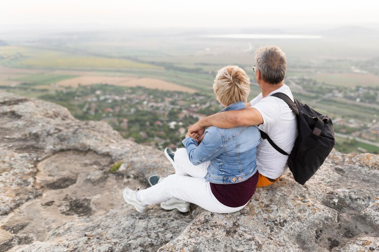 full-shot-senior-couple-sitting-cliff_23-2148656253