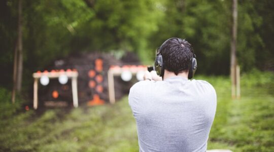 o-foco-raso-foi-disparado-por-tras-de-um-homem-atirando-em-uma-arma-de-fogo_181624-25572