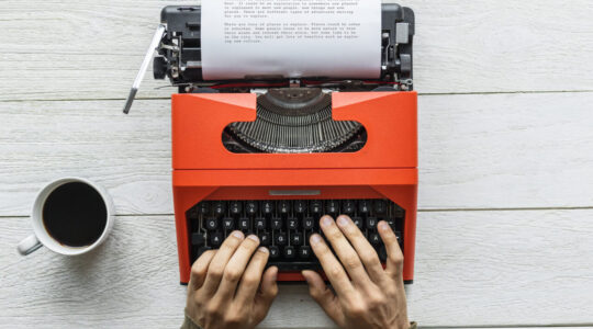 Aerial view of a man typing on a retro typewriter