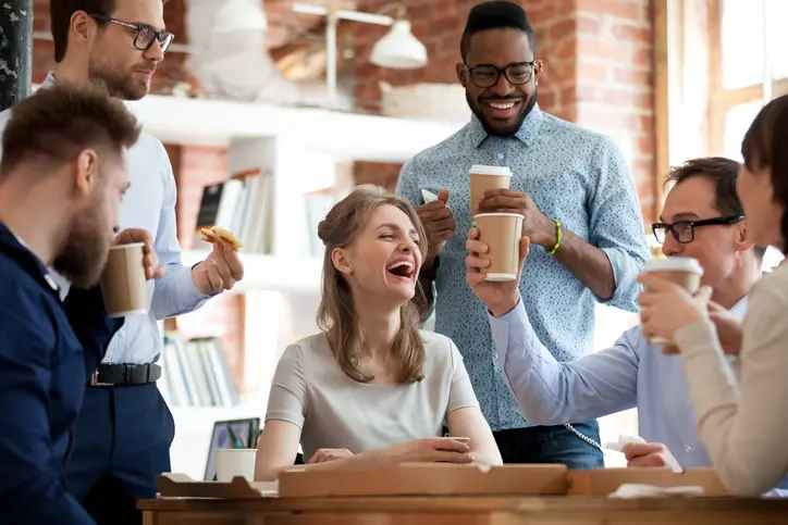 Happy diverse colleagues celebrate during lunch break in office
