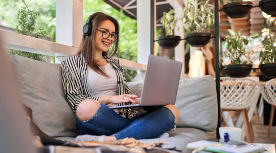 Beautiful student girl learning at home with laptop