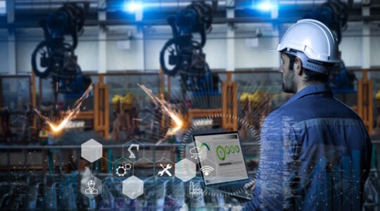 Industry 4.0 Robot concept .Engineers use laptop computers for machine maintenance, automation tools, robot arm at the factory.