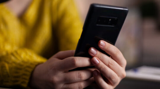 Closeup of social media vlogger with headset holding smartphone