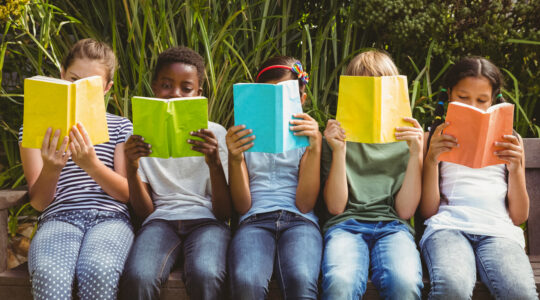 Children reading books at park