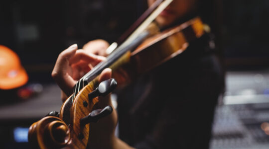 Female student playing violin in a studio