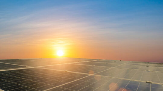 Solar panel against sunset sky background. Windmill, photovoltai