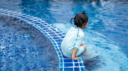 Cute Asian small girl in a pool