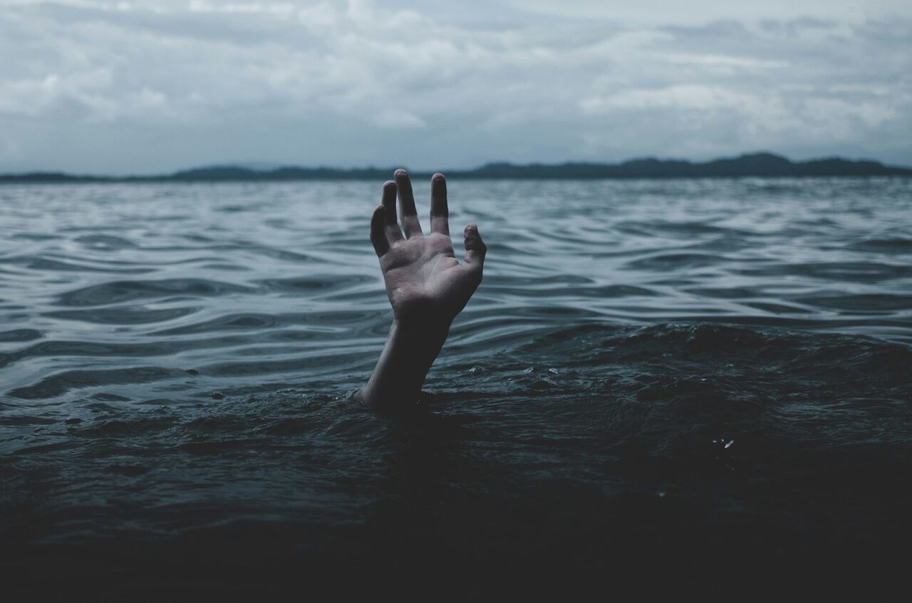 oceano e tempestado, mão pedindo socorro caracterizando a depressão