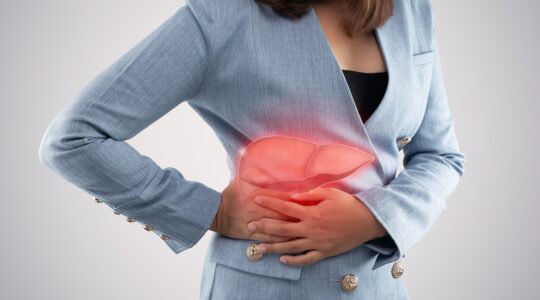 The photo of liver on woman’s body against gray background, Hepa