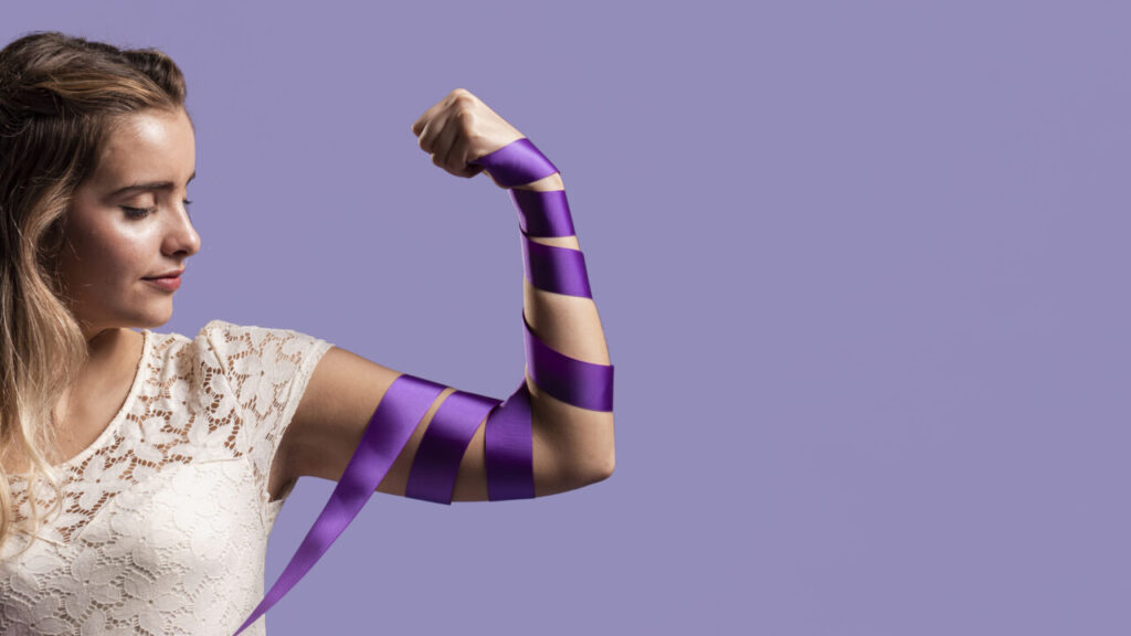 woman-flexing-her-arm-with-ribbon-copy-space
