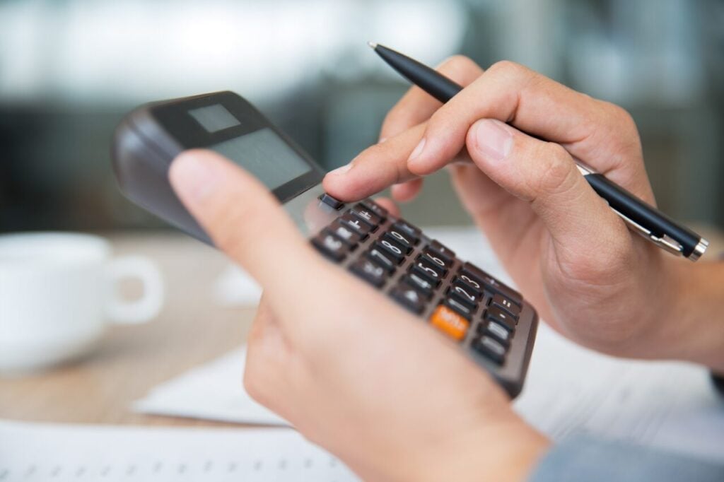 Male hands using calculator