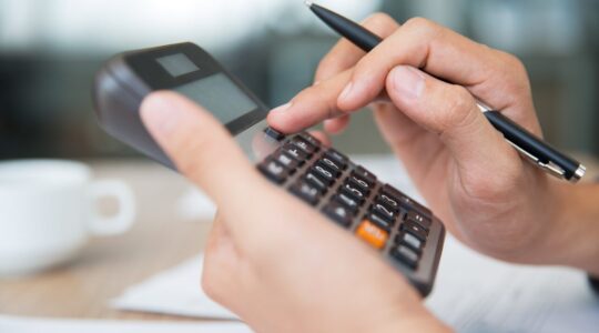 Male hands using calculator