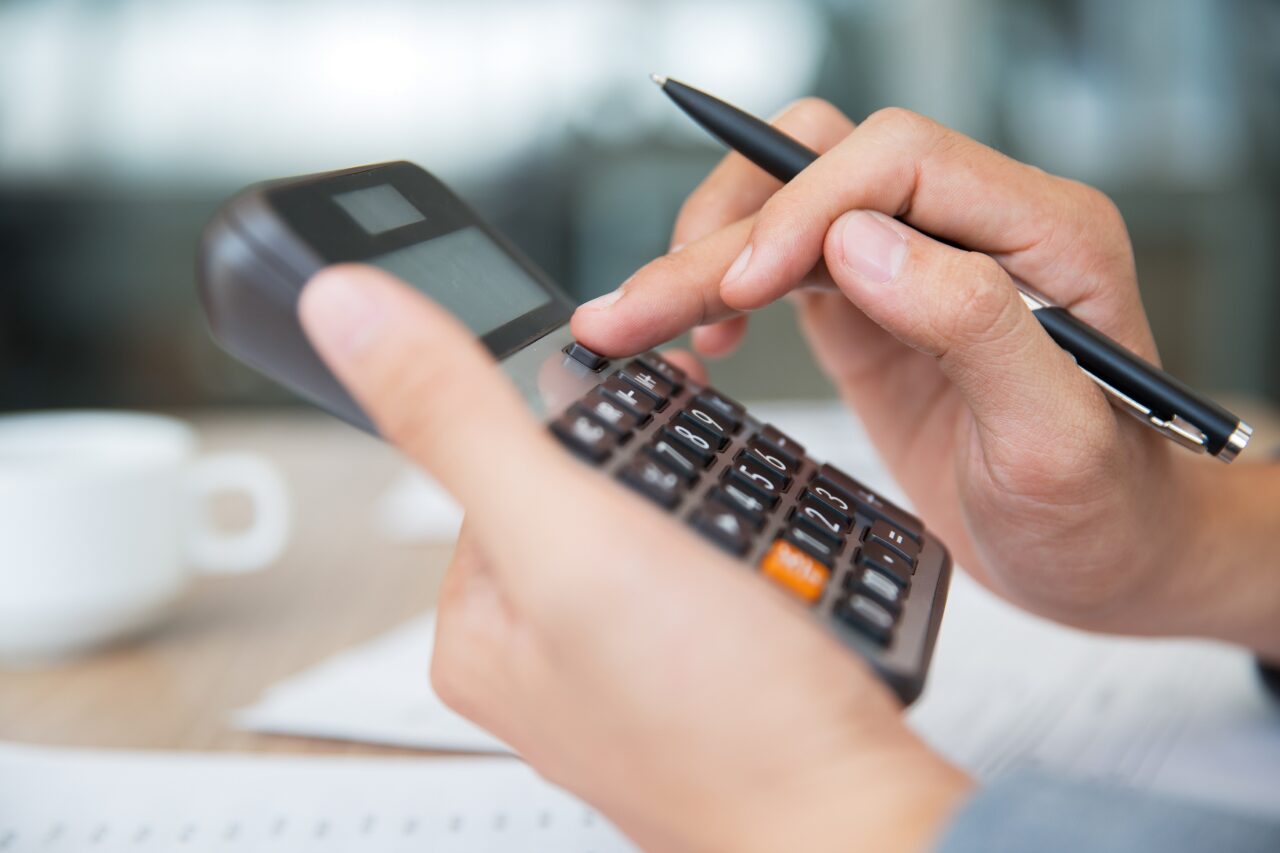Male hands using calculator