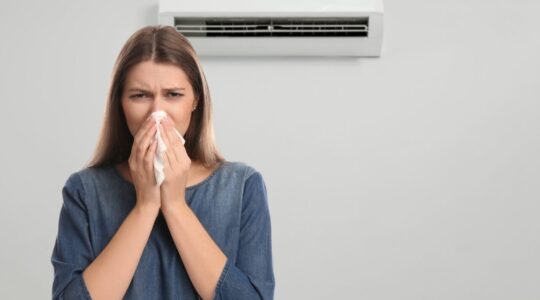 Woman,Suffering,From,Cold,In,Room,With,Air,Conditioner,On