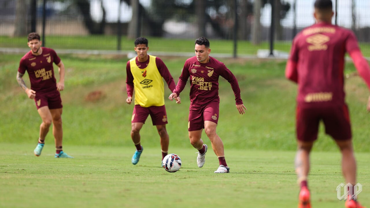 Tobias Figueiredo e Tevis ao fundo, com o volante Fabrizio Peralta (à frente), em treino do Athletico
