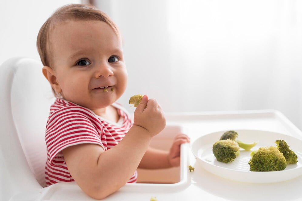 bebe-adoravel-brincando-com-comida_23-2148723061