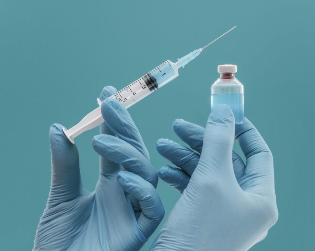 frasco-de-vacina-e-seringa-segurados-por-medico-com-luvas
