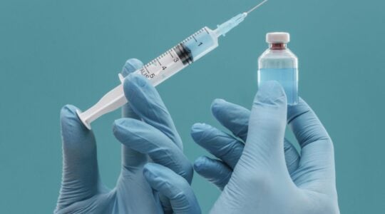 frasco-de-vacina-e-seringa-segurados-por-medico-com-luvas