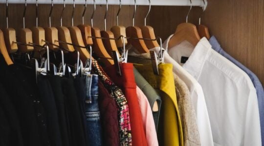 Lot of different clothes hanging in a wardrobe