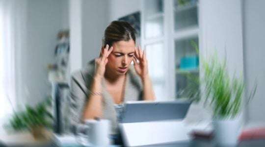 Sick dizzy young woman suffering headache while working on her laptop at home.