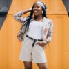 Stylish african american woman by the colored wall
