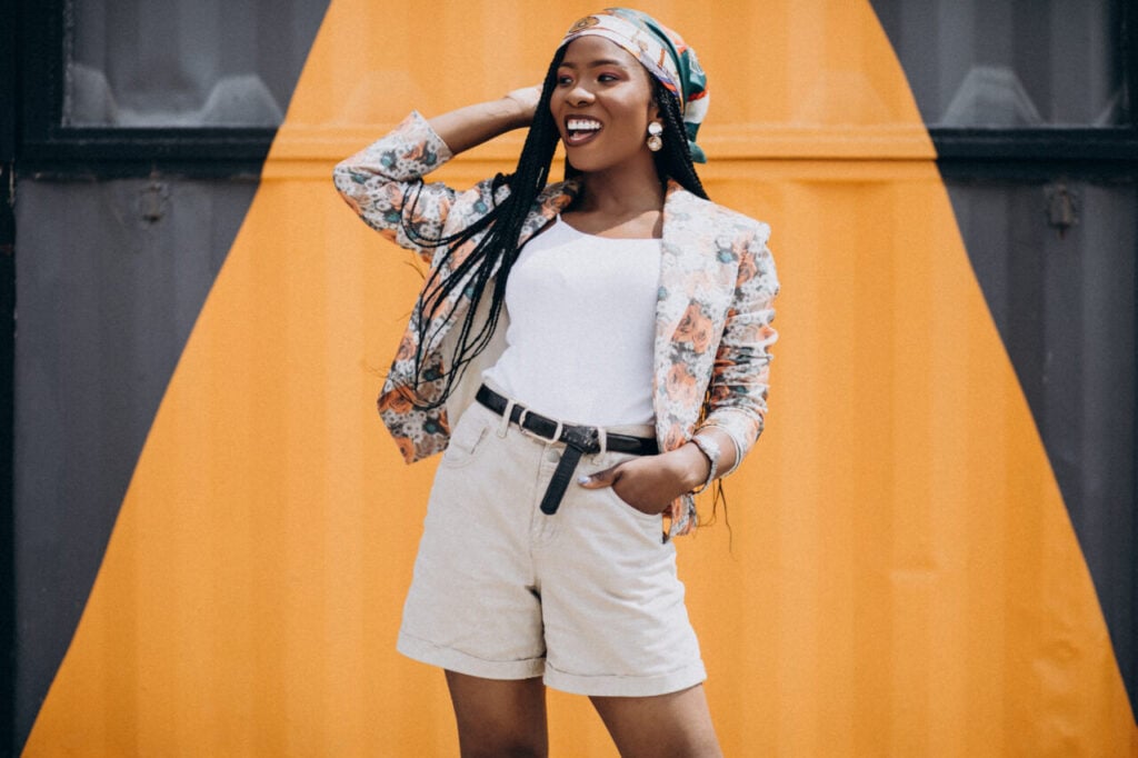 Stylish african american woman by the colored wall