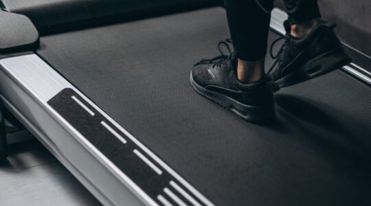 Female legs on the running track at the gym