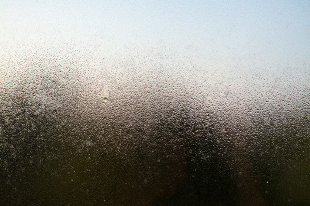 uma-foto-em-close-de-uma-janela-enevoada-com-gotas-de-agua