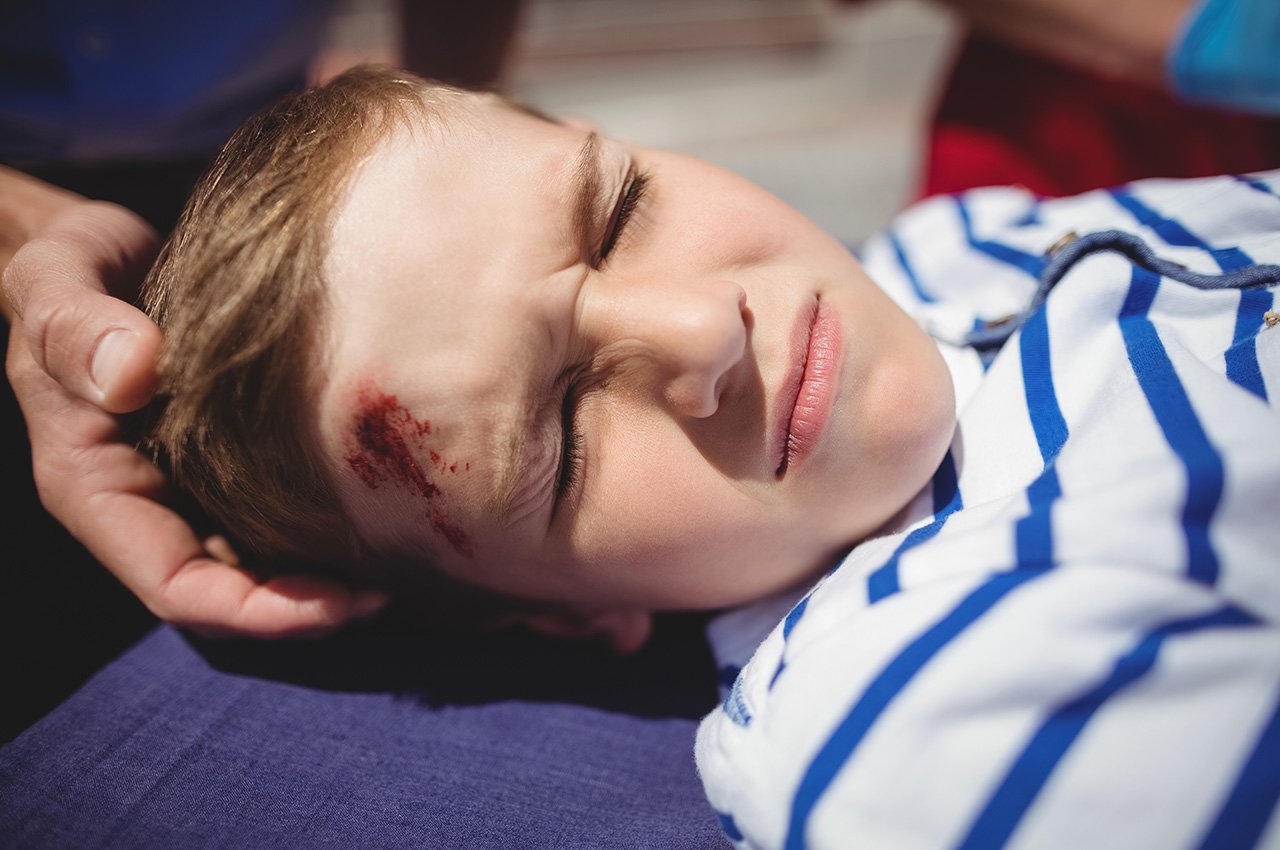 Paramedics examining injured boy on street