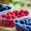 frutas vermelhas separadas em potes plasticos transparentes.