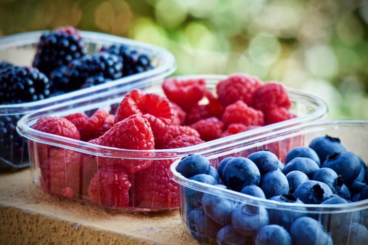 frutas vermelhas separadas em potes plasticos transparentes.