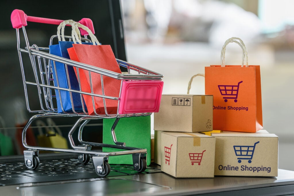 Boxes, bags, shopping cart on a laptop computer keyboard