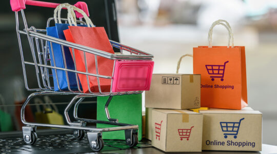 Boxes, bags, shopping cart on a laptop computer keyboard