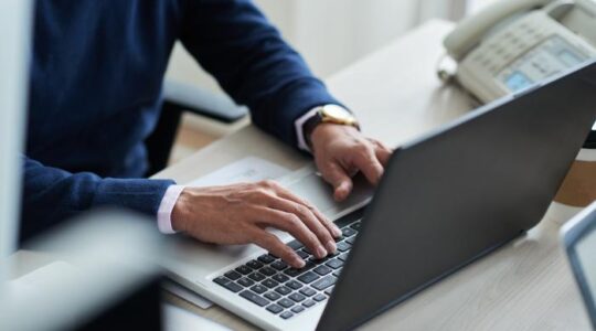 high-angle-view-cropped-employee-work-with-laptop–1-_700