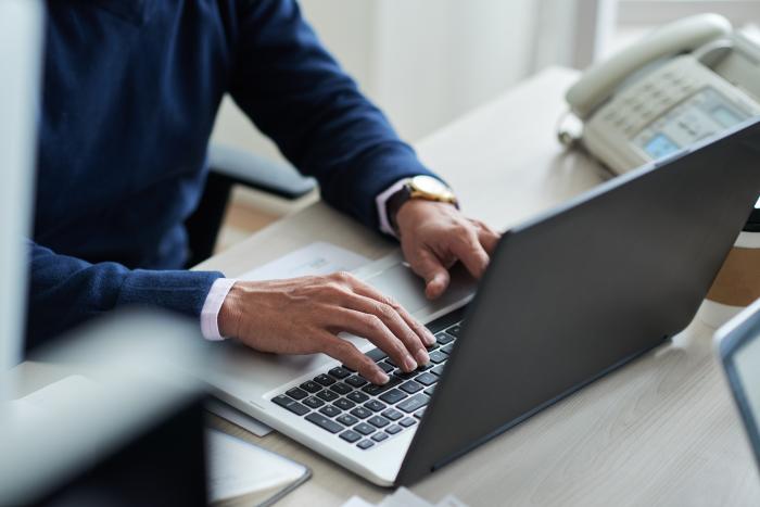 high-angle-view-cropped-employee-work-with-laptop–1-_700