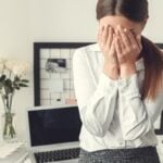 Young woman freelancer indoors home office concept formal style sad
