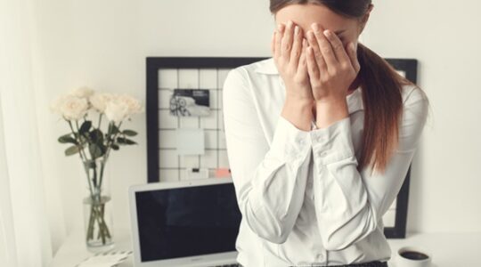 Young woman freelancer indoors home office concept formal style sad