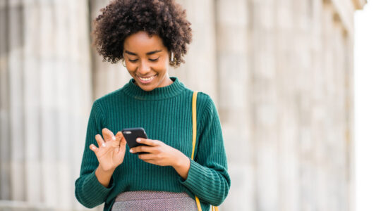 Business woman using her mobile phone outdoors.