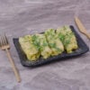 Caucasian cabbage wraps with minced herbs in a black ceramic platter