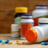 Medicine bottles and tablets on wooden desk