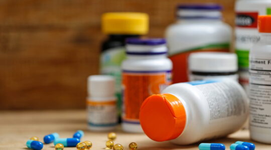 Medicine bottles and tablets on wooden desk