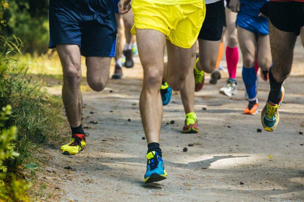 legs running athletes on a forest trail
