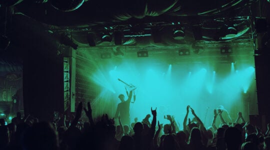Cheering crowd having fun at music festival in a nightclub