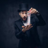Magician showing trick with playing cards.