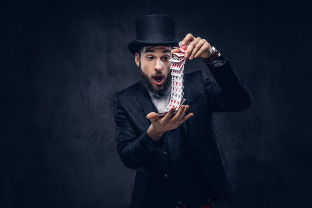 Magician showing trick with playing cards.